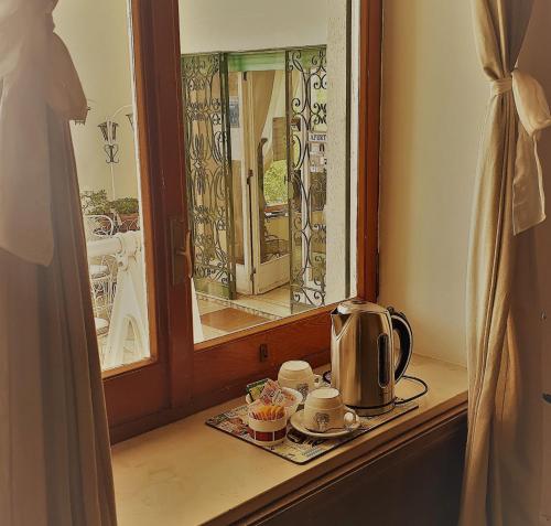 a table with a tea kettle and cups on a window at Il Rifugio B&B Capri in Anacapri