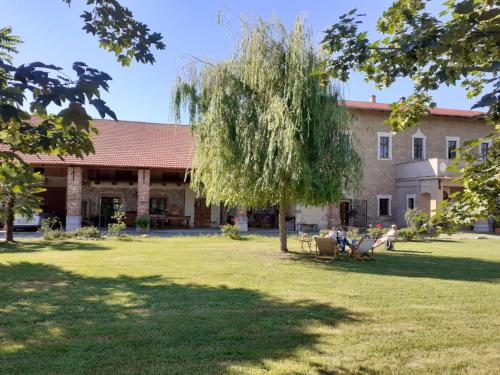 stary budynek z drzewem w ogrodzie w obiekcie B&B Cascina dell'eco w mieście Busca