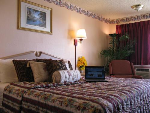 a hotel room with a bed with a laptop on it at Seminole Inn in Seminole