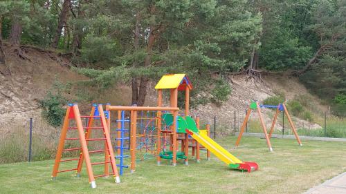 un parque infantil con coloridos equipos de juego en la hierba en Helenka, en Debina