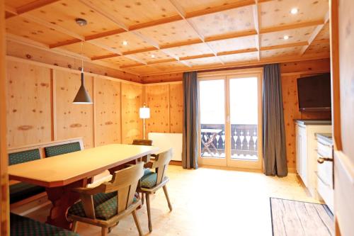 a dining room with a wooden table and chairs at Haus Galgenul in Sankt Gallenkirch