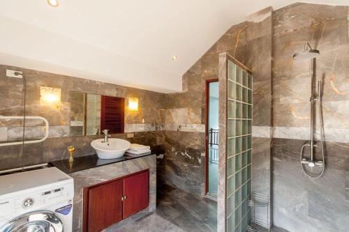 a bathroom with a sink and a shower and a washing machine at Malee Beach A1 in Ko Lanta