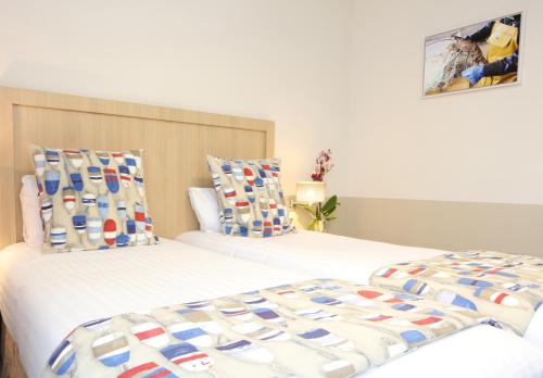 two beds sitting next to each other in a room at Trinite Hotel in La Trinité-sur-Mer