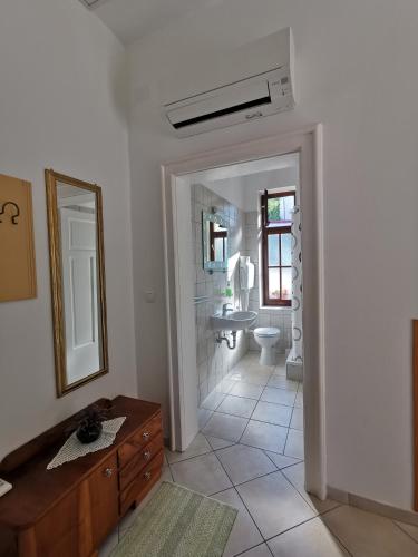 a bathroom with a sink and a toilet and a mirror at Apartments Balticadriatic in Dramalj
