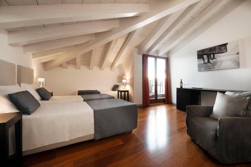 a bedroom with a large bed and a couch at Hotel Del Porto in Torri del Benaco