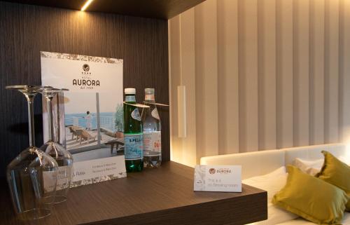 a room with a shelf with bottles of alcohol on it at Hotel Aurora in Lido di Jesolo