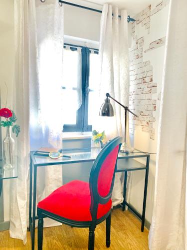 a red chair sitting in front of a desk at Hôtel Paul Riquet in Béziers