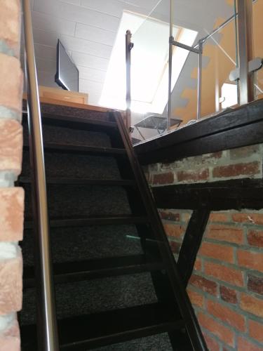 a set of stairs in a room with a brick wall at Pension Riverside in Leverkusen Hitdorf am Rhein - Zentral an der A1 und 59 in Leverkusen