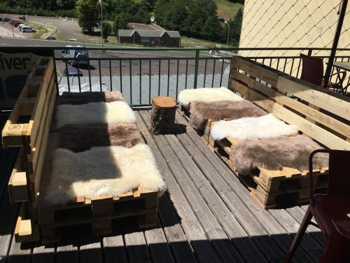 three benches covered in snow on a deck at Hôtel Les Mouflons in Le Mont-Dore