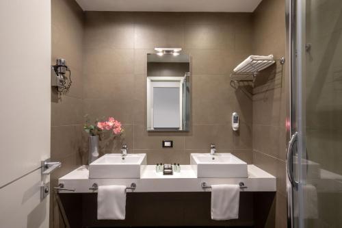 a bathroom with two sinks and a mirror at Stay Inn Rome Via Del Corso in Rome