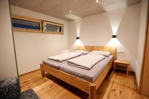 a bedroom with a bed in a room with two lights at Haus Galgenul in Sankt Gallenkirch