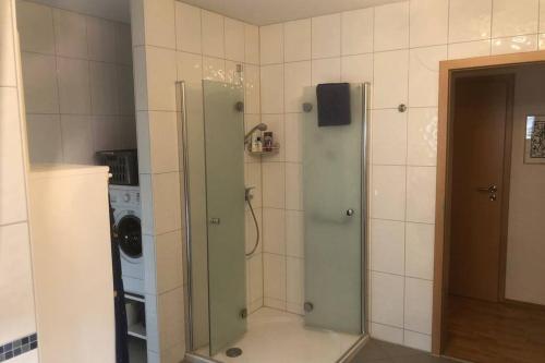 um chuveiro na casa de banho com uma máquina de lavar roupa em NEU Bayreuth direkt im Zentrum und am Hofgarten 150qm mit Klima, 2 Balkons, Aufzug, Familienfreundlich em Bayreuth