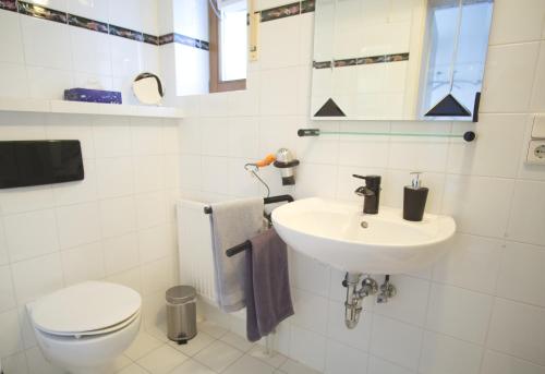 uma casa de banho branca com um lavatório e um WC em Ferienwohnung Am Wingert em Sankt Martin