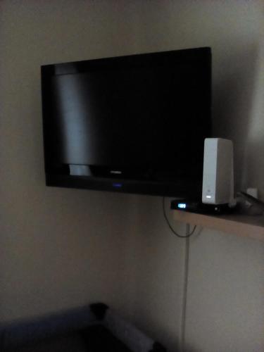 a flat screen tv hanging on a wall at Csilla Apartman in Makó