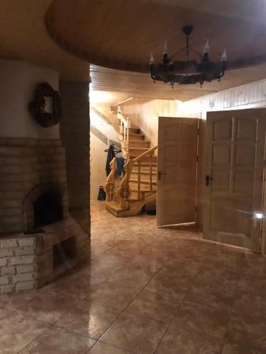 a living room with a stone fireplace and a chandelier at Ялинка in Migovo