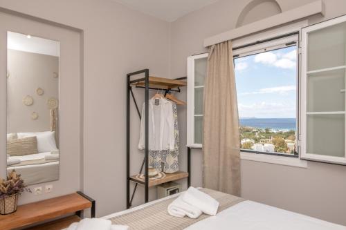 een slaapkamer met een bed en een groot raam bij Porto Vidali in Agios Ioannis