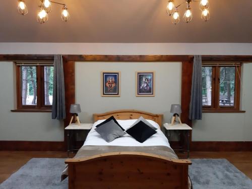 a bedroom with a wooden bed with two tables at Wyldwood Lodge in Cheadle