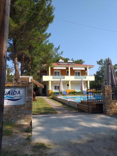 a villa with a swimming pool in front of a house at Laida studios in Prinos