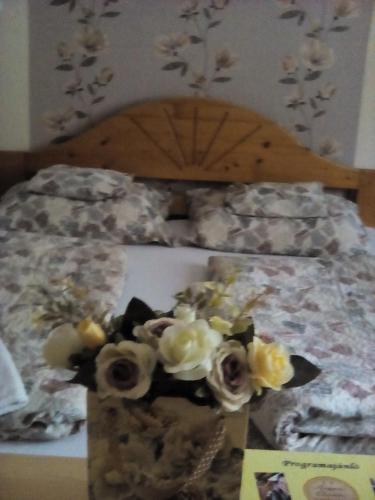 a bed with a bunch of flowers on it at Csilla Apartman in Makó