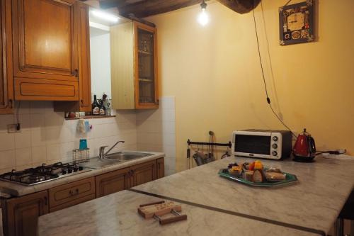 una cucina con lavello e forno a microonde su un bancone di Casa Morè a Carrara