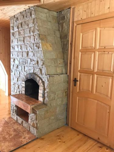 a stone fireplace in a room with a door at Ялинка in Migovo