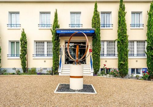 a building with a sculpture in front of it at Best Western Le Vinci Loire Valley in Amboise