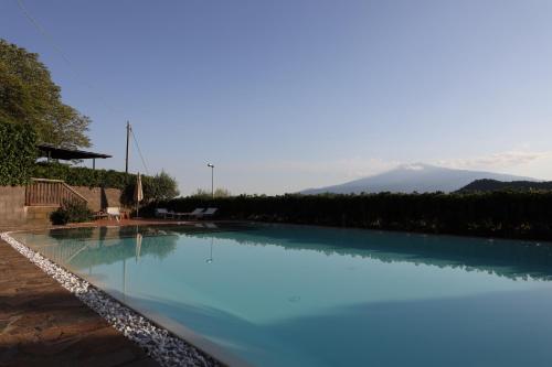 a large swimming pool with blue water at Agriturismo San Cataldo in Motta Camastra