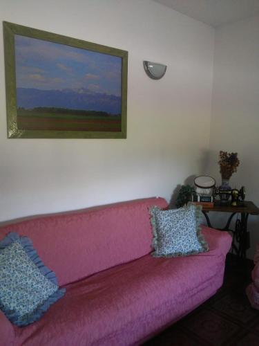 a pink couch in a living room with a painting at Casa Ortensia in Grions