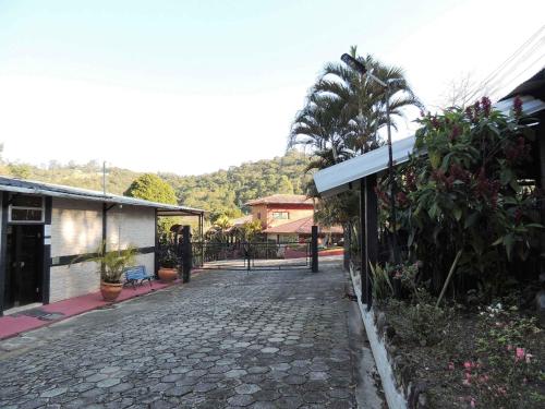 a cobblestone street next to a building with a palm tree at Pousada Juriti - Eco Hotel in São Roque