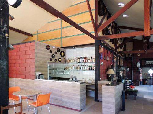 a restaurant with a bar with orange chairs and a table at Pousada Juriti - Eco Hotel in São Roque