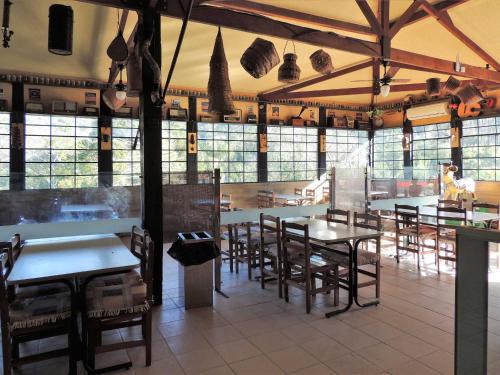 a restaurant with tables and chairs and windows at Pousada Juriti - Eco Hotel in São Roque