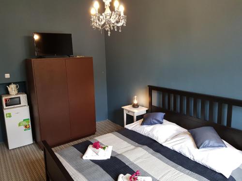 a bedroom with two beds and a television and a chandelier at Vila Janáčkova - 1st republic villa in Trutnov