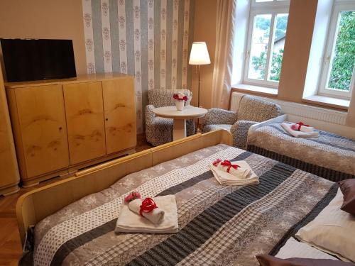 a hotel room with two beds with towels on them at Vila Janáčkova - 1st republic villa in Trutnov