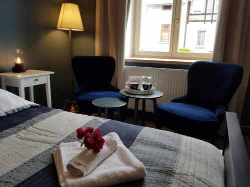 a hotel room with a bed with a towel and two chairs at Vila Janáčkova - 1st republic villa in Trutnov