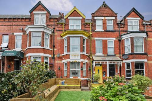 an apartment building with a garden in front of it at Chomley holiday flats in Scarborough