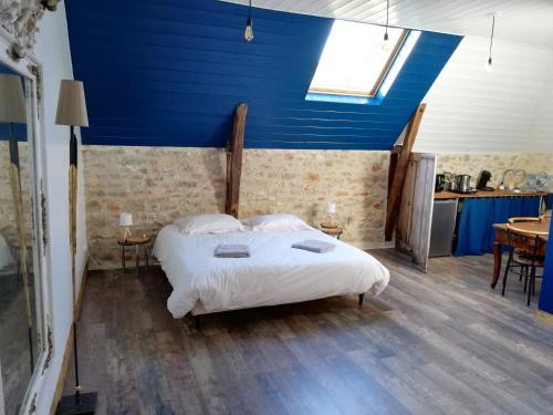 a bedroom with a bed with a blue ceiling at Le Puits de Garival in Tour-de-Faure