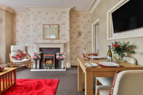 a living room with a fireplace and a table at Chomley holiday flats in Scarborough