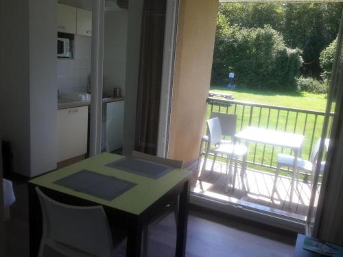 a room with a table and a balcony with a table and chairs at Le Havre de Paix 8 , Les Hauts de Honfleur, Piscine, WIFI et Parking gratuits in Équemauville