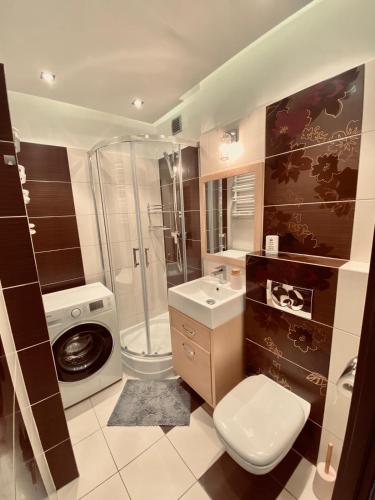 a bathroom with a toilet sink and a shower at Przytulne mieszkanie na Przymorzu w Gdańsku in Gdańsk
