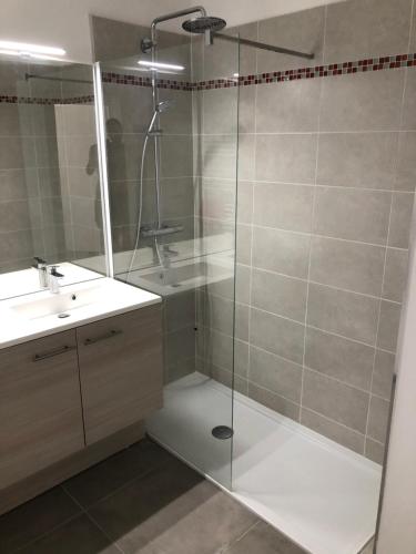 une salle de bain avec une douche en verre et un lavabo dans l'établissement Appartement T3 neuf Sur les toits avec terrasse, à Hyères