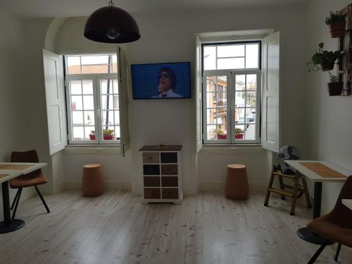 a room with two windows and a tv on the wall at Cork Train Station Guesthouse in Esmoriz
