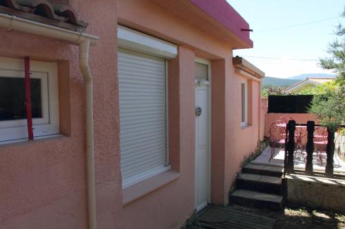 un edificio con una puerta y una escalera a una casa en La Pommeraie Studio, en Vernet-les-Bains