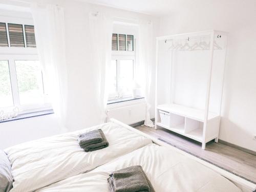 a white bedroom with a bed and a mirror at Klärchen's Stube in Telgte