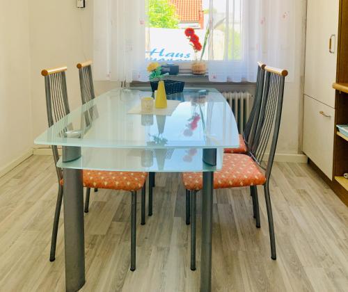 a glass dining room table with four chairs at Haus Kormoran Borkum in Borkum
