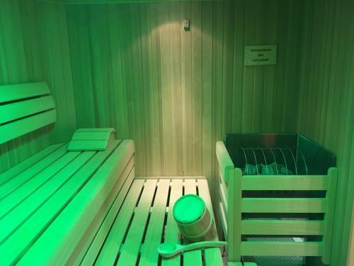 a green room with a bed and a crib at Hotel Gasthof Familie Czepl in Ernsthofen