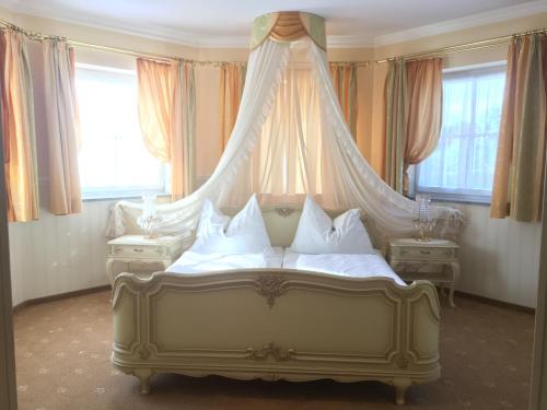 a bed with a canopy in a room with windows at Hotel Gasthof Familie Czepl in Ernsthofen