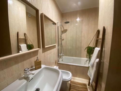 uma casa de banho com um lavatório, uma banheira e um WC. em Samil55 em Vigo