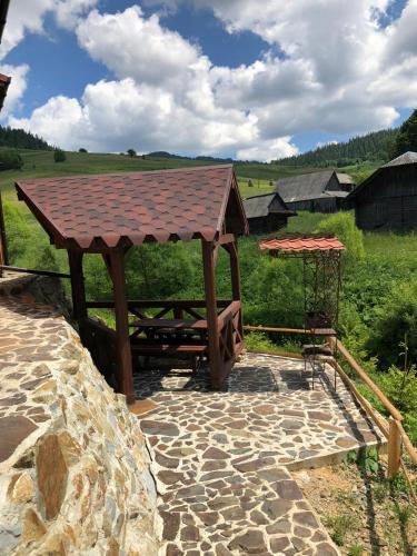 a wooden picnic table with a roof on a field at Шервуд in Myta
