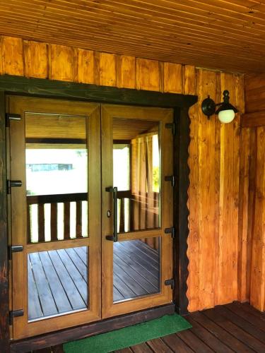 an entry door to a cabin with wooden walls at Шервуд in Myta
