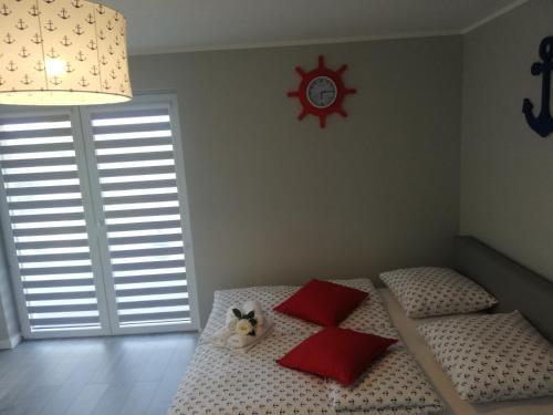 a bedroom with two beds with red pillows and a clock at MARKAS in Rewa